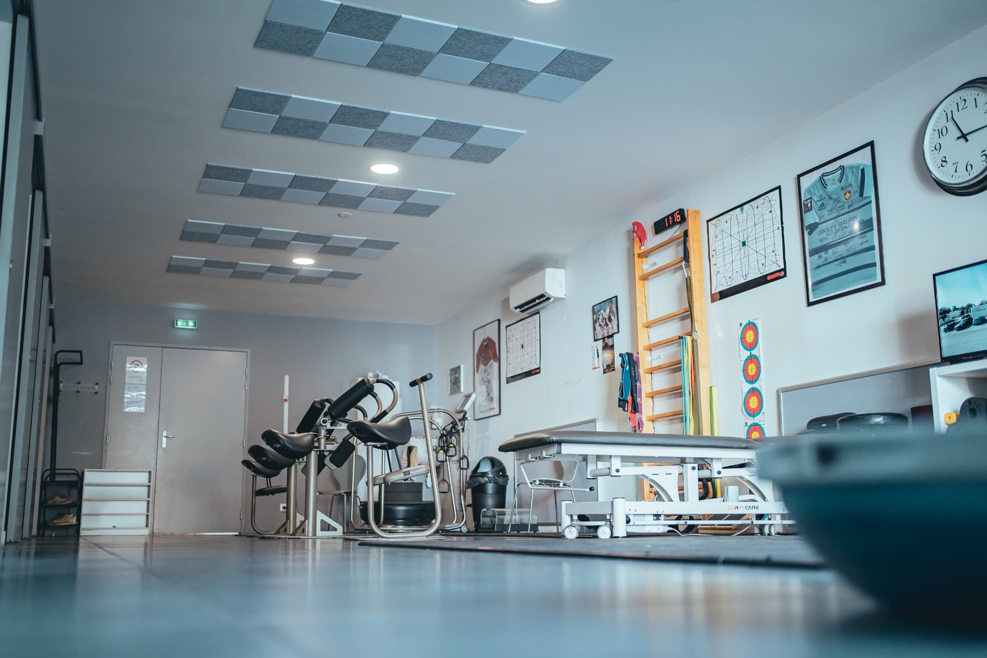 Salle de rééducation avec appareils de posture et tables de soins