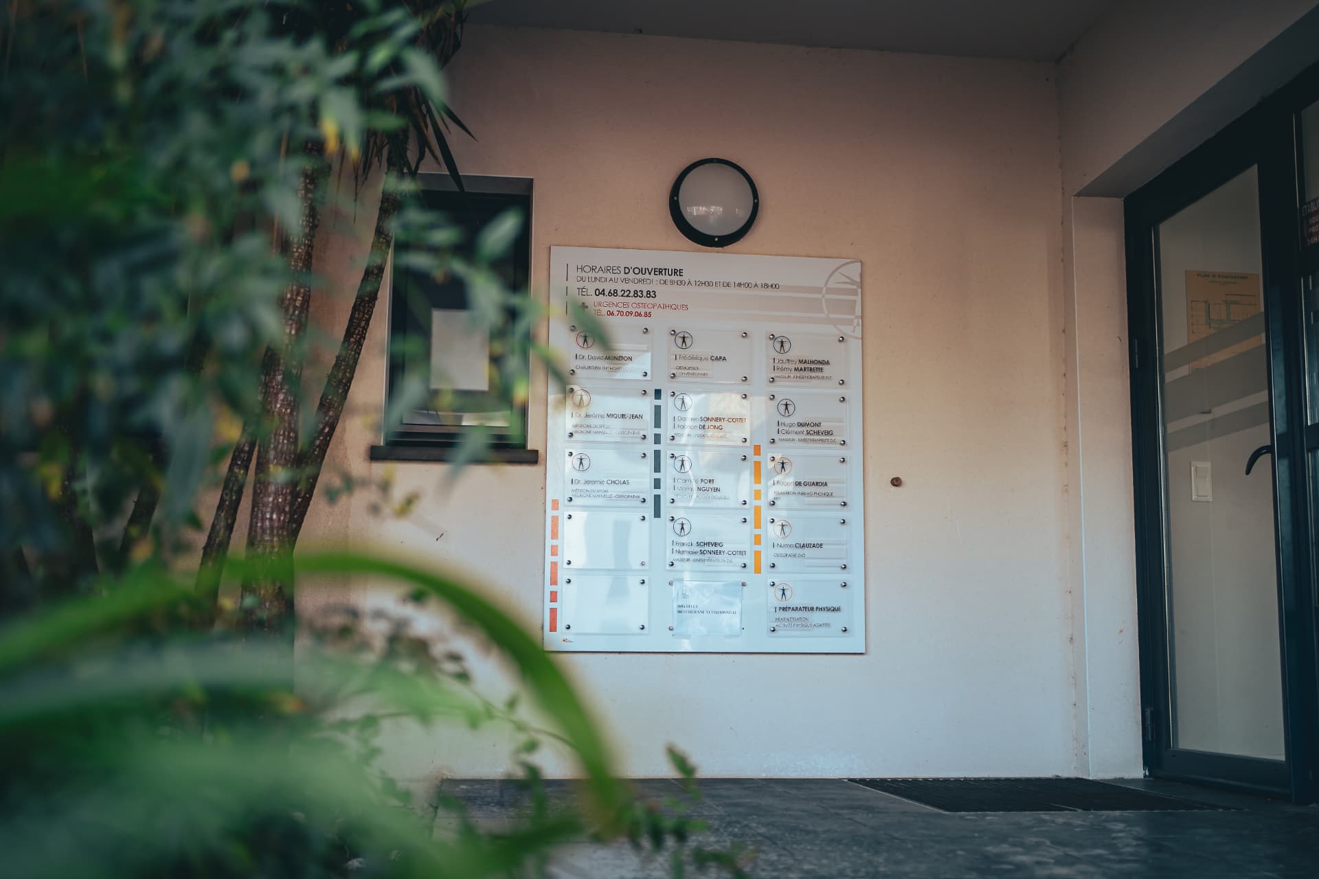 Panneau des praticiens et horaires à l'entrée de la clinique